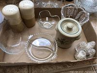 Top-view photo showing three glass bowls, two salt and pepper shaker sets, glass pickle dish, large ceramic salt and pepper holder, and small decorative lidded canister arranged in a box.