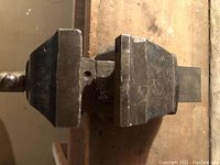 Top view of a mechanical metal bench vice showing the clamping jaws and part of the screw tightening mechanism.