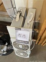 Holmes Twin Window Fan and owner's guide with two box fans stacked nearby