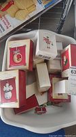 Multiple Hallmark Keepsake ornaments in original boxes in a white tub.