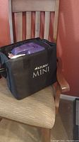 Keurig Mini branded black soft carrying case with the purple coffee maker inside, showing overall lot contents packed for transport or storage.