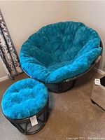 Papasan chair and ottoman with blue cushions shown from front view.