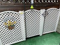 Three white plastic lattice fence panels arranged side-by-side showing full view and top curved design.