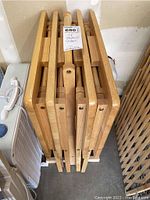 Top view showing four stacked wooden TV tables with rectangular tops and flat legs, displaying natural wood grain finish.