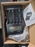 Top view of the LiitoKala Engineer Lii-500 battery charger in open box including power cord and user manual.