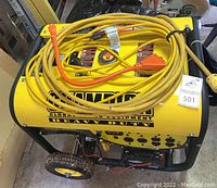 Front view of yellow Champion generator with extension cord coiled on top