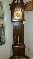 Full front view of clock case with bonnet, dial, weights visible through glass door