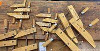 Group of assorted wood clamps on wooden surface showing multiple clamps from Jorgensen and Craftsman, with wooden handles and metal screws.