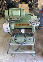 Front view of green Grizzly planer on stand with control box and power cord