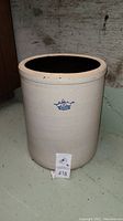 Front view of large vintage cream stoneware crock with blue crown and number 8 stamp on surface.