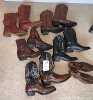 Overview of all seven pairs of cowboy boots arranged on carpet, showing variety of colors including brown and black.