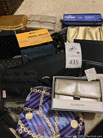 Photo showing multiple assorted travel wallets, small evening bags, and wallets including a Liz Claiborne wallet in original box and other colorful wallets and pouches.