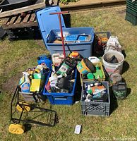 Overview of gardening supplies including crates, tubs, garden cart, tools and chemical containers