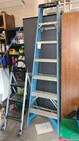 Photo showing the full Werner aluminum 7ft ladder next to the 47in step stool with wheels.