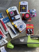 Image of various tiling and garage tools including Shark vacuum, furniture sliders, tile spacer roller, and sanding pads.
