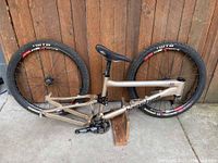 Side view of Banshee Roam frame with attached saddle, crankset, and both wheels mounted showing overall condition and frame branding.