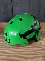 Green Kali youth small bike helmet with black graphic and multiple ventilation holes, showing scratches.