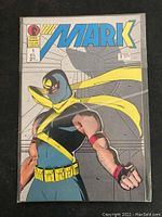 Front cover of The Mark Issue #1 comic book showing masked superhero in blue, yellow and red costume with price sticker.