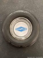 Top view of the vintage Goodyear tire ashtray showing the tire lettering and the metal center with Goodyear logo.