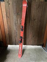 Full view of one red Head Mojo 90 ski showing white branding and surface scratches.