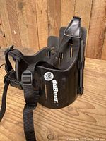Front and side view of black DaDeer lacrosse kidney pad showing brand logo, plastic exterior, and adjustable straps with buckles attached.