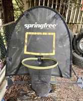 Springfree outdoor basketball hoop attached to a frame, showing mesh backboard with Springfree logo, circular rim, and catch net.