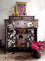 Frontal view of painted wooden dresser with decorative decoupage, showing two small top drawers and overall finish.
