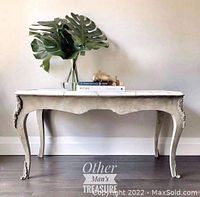 Photo shows a wooden coffee table painted in a faux stone and marble finish with ornate curved legs. The table is 21 inches tall, 38 inches long, and 20 inches deep. Decorative leaves and books are on top for staging only.
