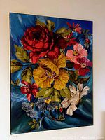 Front view of original mix media floral wall art with bold red, yellow, pink, white and blue flowers on a dark bluish background