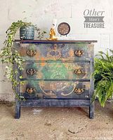 Front view of dresser showing distressed green and black finish with old world fair decals and brass hardware