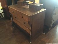 Full view of antique wooden dresser showing the front with drawers and turned spindles.