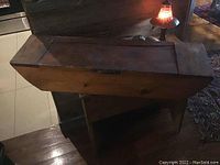 Side view showing the rectangular wooden storage container with hinged lid and natural wood finish.