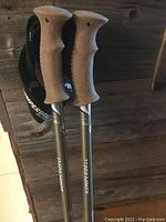 Closeup of cork ergonomic grips and wrist straps labeled Komperdell, top portion of poles visible