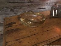 Murano glass bowl ashtray viewed from above and side angles, showing gold fleck rim and bubble inclusions inside clear glass.