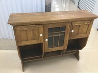 Front view of oak hutch top showing three cabinets and open cubbies
