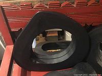 Four dark wooden frame mirrors with irregular tree trunk shapes, stacked and partially visible on wooden surface.