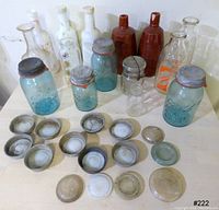 All items displayed together: blue Ball jars, clear glass bottles, milk bottles, brown stoneware bottles, many zinc and other metal lids