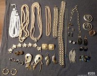 Photo showing full jewelry lot including necklaces, large and small pearl style beads, various clip-on and pierced earrings, and other jewelry items.