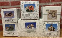 Six original Charming Tails figurine boxes showing product names and artwork