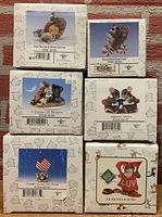 Back view of original boxes showing item names and barcodes for each Charming Tails figurine in the lot.