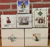 Boxed lot of 6 Charming Tails figurines stacked showing front artwork with titles and Charming Tails branding on boxes.