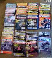 Photo showing 28 issues of Open Wheel magazine arranged in rows, featuring sprint car and racing engine covers.