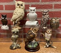 Full lot of 8 owl figurines arranged on a shelf, showing size and style variety