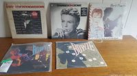 Five David Bowie vinyl albums in protective sleeves on flat surface showing cover art