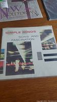 Simple Minds 'Sons and Fascination' vinyl album cover photo with abstract blurred lights and white background.