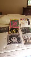 Seven vinyl LP albums arranged on mattress: three The Doors and four Jimi Hendrix.