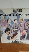 Vinyl record cover titled 'Penthouse and Pavement' by band Heaven 17, featuring a group illustration of six men in suits.