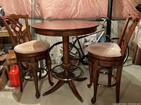 Three-piece set in basement setting showing round table and two stools