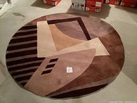 Full view of the round geometric patterned rug with muted earthy colors on floor.