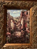 Close-up of painting showing detailed rustic village scene with cobblestone path and greenery